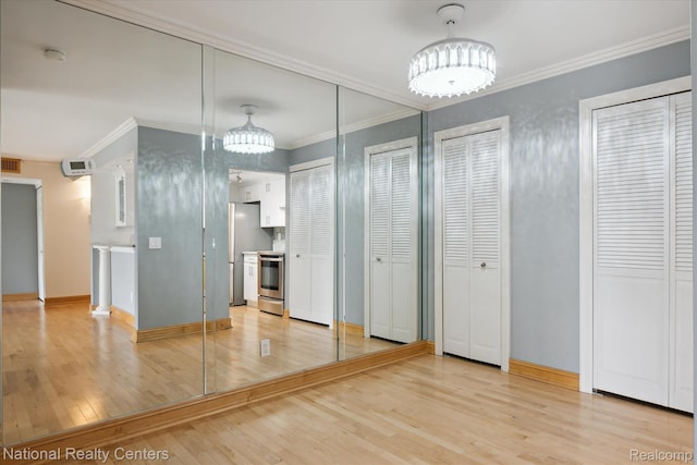 3559 Port Cove Dr Unit 17, Waterford, MI 48328 - unfurnished bedroom with a chandelier, multiple closets, light wood-type flooring, and ornamental molding