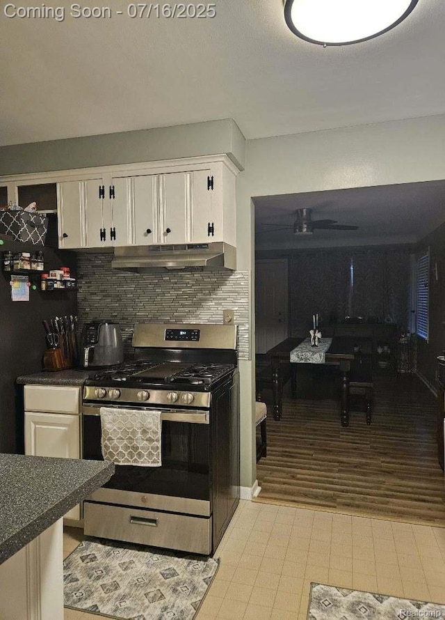 27315 Gilbert Dr, Warren, MI 48093 - kitchen with stainless steel gas range oven, white cabinetry, under cabinet range hood, and decorative backsplash