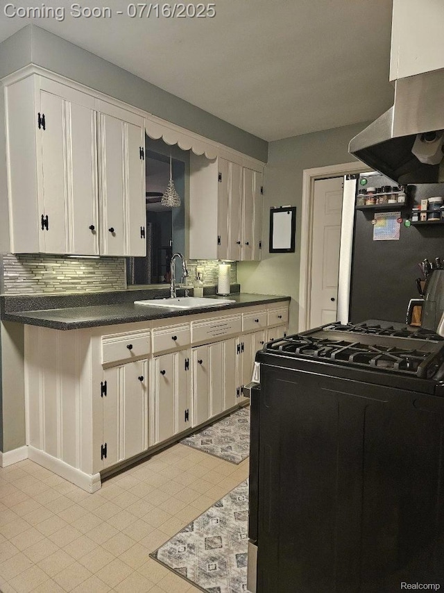 27315 Gilbert Dr, Warren, MI 48093 - kitchen featuring black gas range oven, dark countertops, decorative backsplash, and exhaust hood