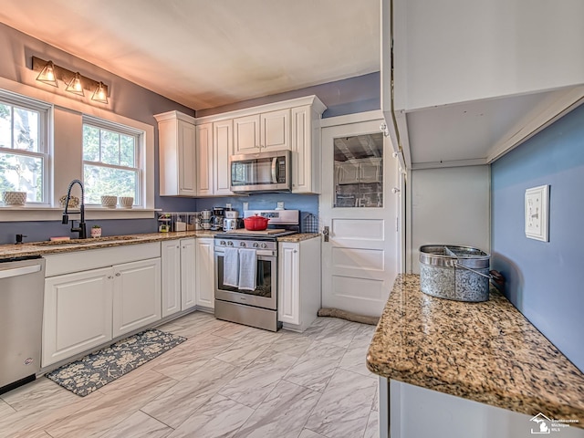 525 Godfroy Ave, Monroe, MI 48162 - kitchen with stainless steel appliances, light marble finish flooring, white cabinets, and light stone counters