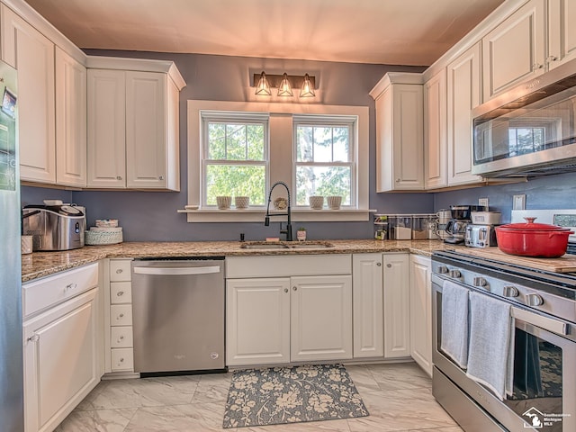 525 Godfroy Ave, Monroe, MI 48162 - kitchen with appliances with stainless steel finishes, light marble finish floors, white cabinetry, and light stone counters