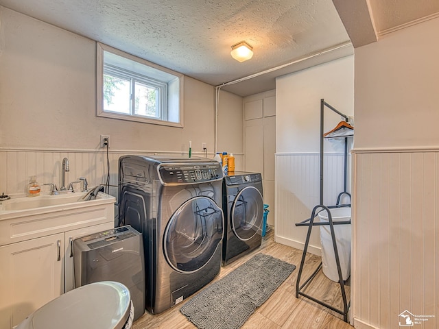 525 Godfroy Ave, Monroe, MI 48162 - washroom with washer and clothes dryer, light wood-style floors, a wainscoted wall, and a textured ceiling