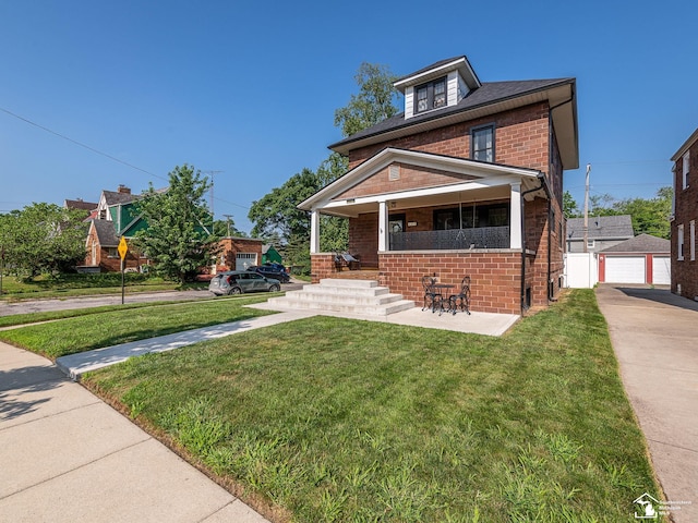 525 Godfroy Ave, Monroe, MI 48162 - american foursquare style home featuring brick siding, a porch, a front yard, and a detached garage