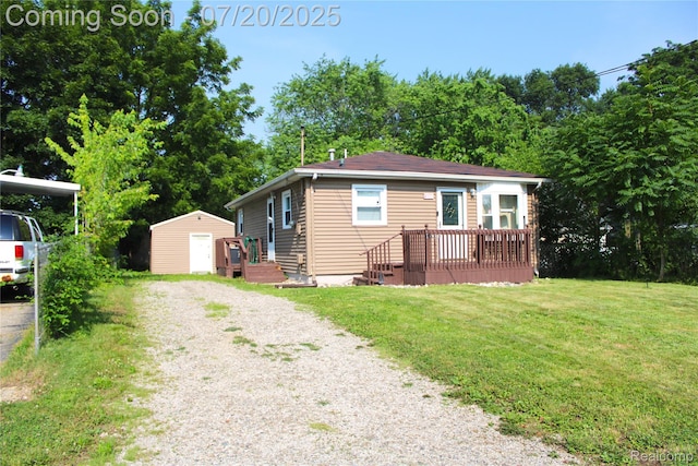 1030 Meida St, Flint, MI 48532 - view of front of home with a storage shed, a front yard, gravel driveway, and a deck