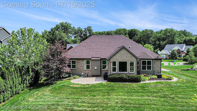 23395 Stoneleigh Ct, South Lyon, MI 48178 - back of property featuring brick siding, a patio area, and a lawn