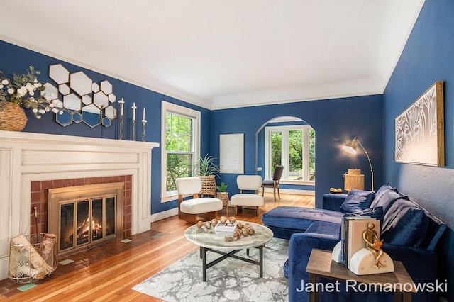 1055 San Lucia Dr SE, Grand Rapids, MI 49506 - living area with wood finished floors, a brick fireplace, and arched walkways