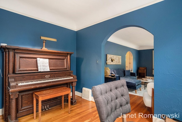 1055 San Lucia Dr SE, Grand Rapids, MI 49506 - living area featuring arched walkways, wood finished floors, and ornamental molding