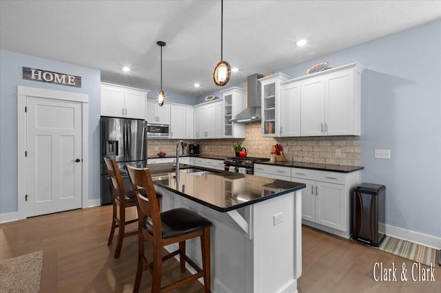 4454 Keena Ct NE Unit 71, Grand Rapids, MI 49525 - kitchen featuring wall chimney exhaust hood, appliances with stainless steel finishes, dark countertops, wood finished floors, and recessed lighting