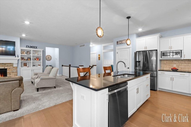 4454 Keena Ct NE Unit 71, Grand Rapids, MI 49525 - kitchen featuring appliances with stainless steel finishes, dark countertops, open floor plan, light wood-style flooring, and recessed lighting