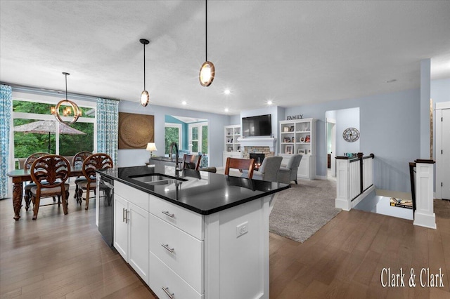 4454 Keena Ct NE Unit 71, Grand Rapids, MI 49525 - kitchen featuring dark countertops, dark wood finished floors, a kitchen island with sink, hanging light fixtures, and recessed lighting
