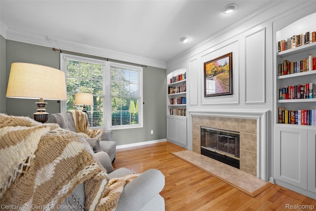 1760 Bedlington Ct, Rochester Hills, MI 48307 - living room with crown molding, light wood-style floors, a tile fireplace, and built in shelves