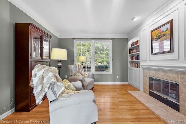 1760 Bedlington Ct, Rochester Hills, MI 48307 - living room with crown molding, light wood-type flooring, a tile fireplace, and built in shelves