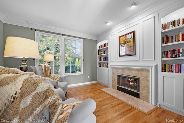 1760 Bedlington Ct, Rochester Hills, MI 48307 - living area with ornamental molding, a tile fireplace, light wood finished floors, and built in features
