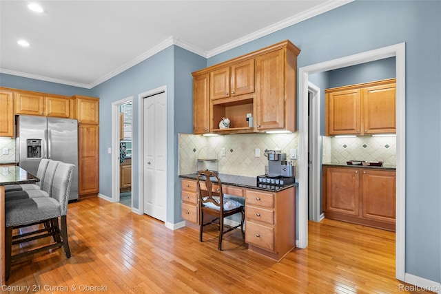 1760 Bedlington Ct, Rochester Hills, MI 48307 - kitchen featuring stainless steel fridge with ice dispenser, light wood finished floors, ornamental molding, tasteful backsplash, and built in study area
