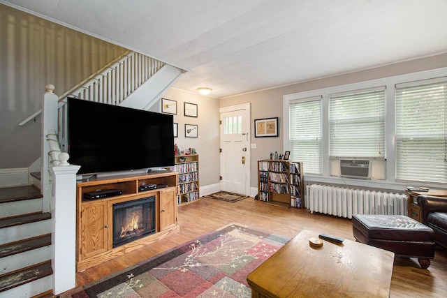 1019/1021 N Michigan Ave, Howell, MI 48843 - living area with radiator heating unit, stairway, cooling unit, and wood finished floors