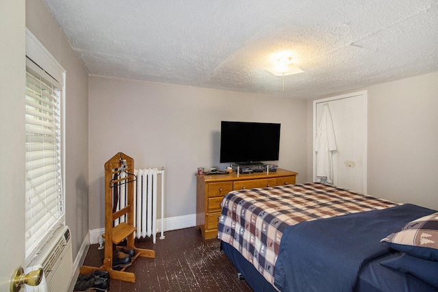1019/1021 N Michigan Ave, Howell, MI 48843 - bedroom featuring a textured ceiling, dark wood-type flooring, and radiator heating unit