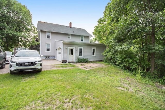 1019/1021 N Michigan Ave, Howell, MI 48843 - back of house with a chimney, a lawn, and an attached garage