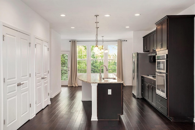 2817 Hartwick Dr, Rochester Hills, MI 48307 - kitchen featuring light stone countertops, a kitchen island with sink, a chandelier, dark wood-type flooring, and dark brown cabinetry