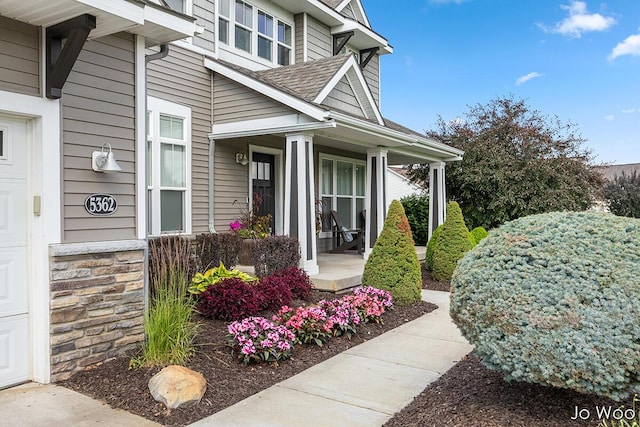 5362 Settlers Grove Rd NE, Belmont, MI 49306 - view of exterior entry featuring a porch, a garage, and a shingled roof