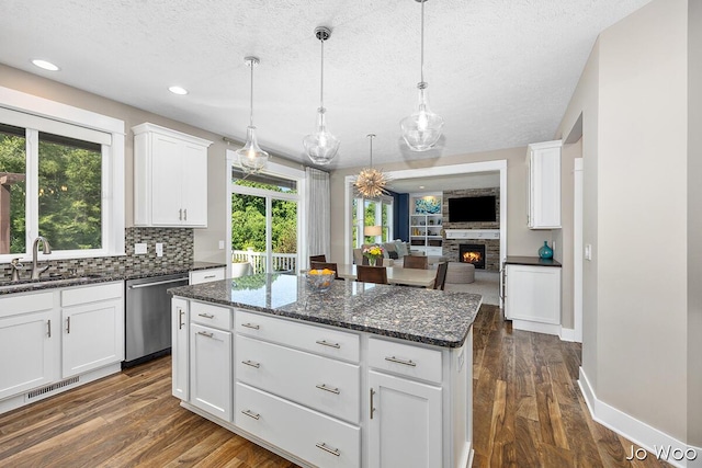 5362 Settlers Grove Rd NE, Belmont, MI 49306 - kitchen featuring dishwasher, open floor plan, a textured ceiling, decorative backsplash, and a kitchen island
