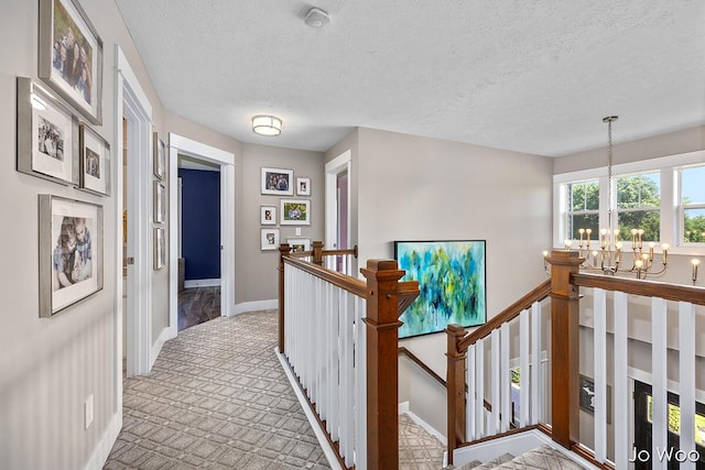 5362 Settlers Grove Rd NE, Belmont, MI 49306 - hall featuring a chandelier, an upstairs landing, a textured ceiling, and carpet flooring