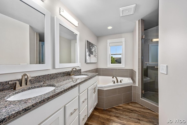 5362 Settlers Grove Rd NE, Belmont, MI 49306 - bathroom with double vanity, a bath, a shower stall, and wood finished floors