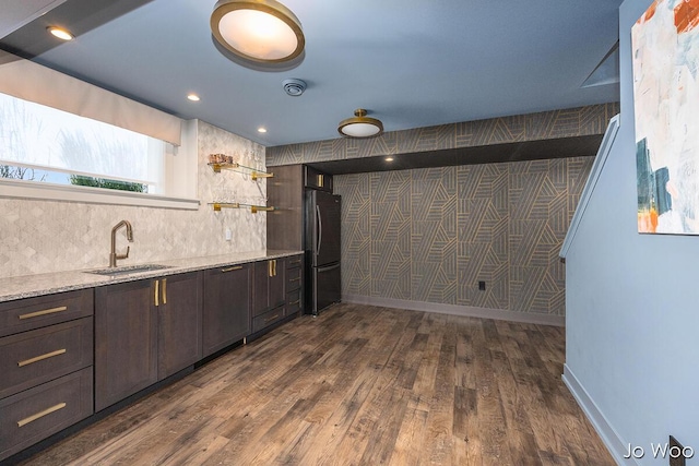 5362 Settlers Grove Rd NE, Belmont, MI 49306 - kitchen featuring freestanding refrigerator, dark brown cabinetry, dark wood-style floors, backsplash, and light stone countertops