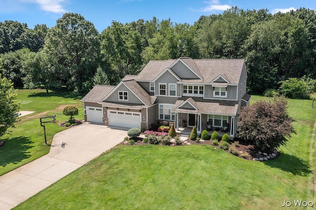 5362 Settlers Grove Rd NE, Belmont, MI 49306 - view of front of house with driveway, a garage, a porch, a front lawn, and stone siding