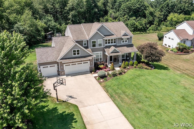 5362 Settlers Grove Rd NE, Belmont, MI 49306 - craftsman-style house featuring a porch, driveway, stone siding, a front lawn, and a garage