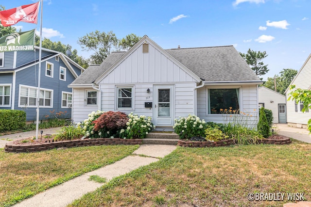 302 W 22nd St, Holland, MI 49423 - bungalow-style home featuring board and batten siding, roof with shingles, and a front yard