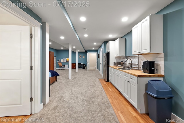 1120 Wyandotte Ave, Royal Oak, MI 48067 - kitchen with butcher block countertops, freestanding refrigerator, white cabinets, decorative backsplash, and recessed lighting