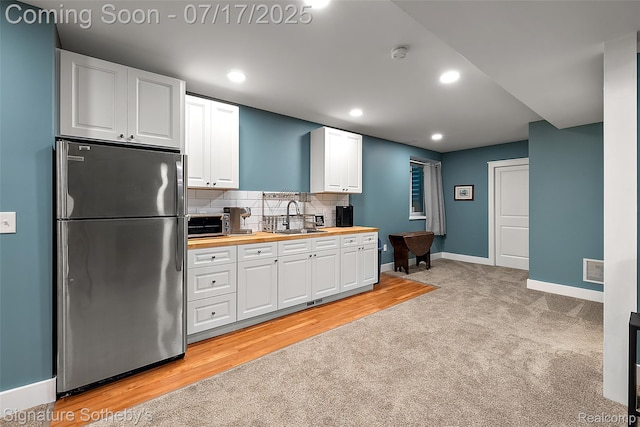 1120 Wyandotte Ave, Royal Oak, MI 48067 - kitchen with freestanding refrigerator, wooden counters, white cabinetry, decorative backsplash, and light carpet