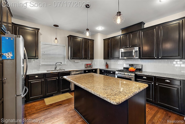 1120 Wyandotte Ave, Royal Oak, MI 48067 - kitchen with stainless steel appliances, backsplash, dark wood finished floors, light stone counters, and a center island