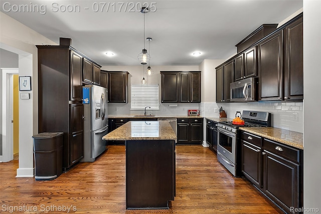 1120 Wyandotte Ave, Royal Oak, MI 48067 - kitchen with stainless steel appliances, dark brown cabinetry, a center island, decorative light fixtures, and decorative backsplash