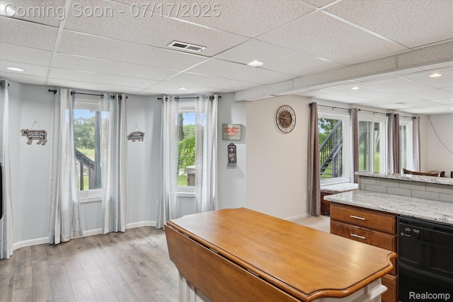 1847 Brandy Ln, Brighton, MI 48114 - kitchen featuring a paneled ceiling, black dishwasher, a kitchen island, light wood-style floors, and healthy amount of natural light