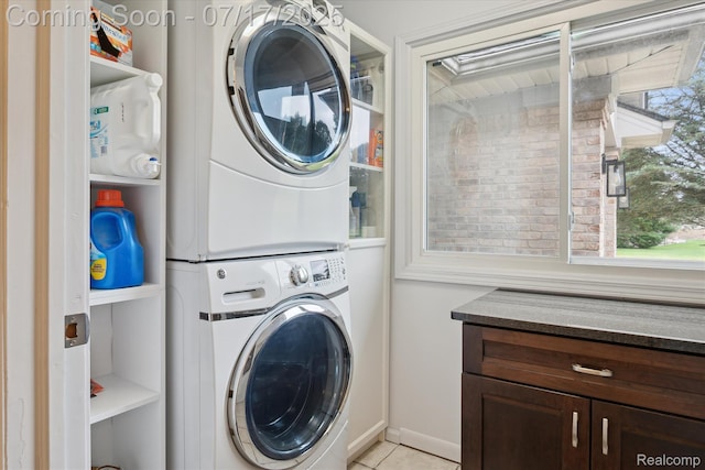 1847 Brandy Ln, Brighton, MI 48114 - washroom with stacked washer and clothes dryer, light tile patterned flooring, and cabinet space