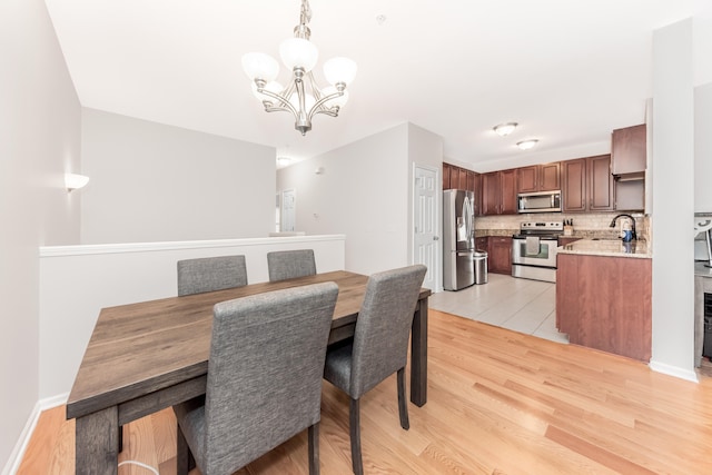 241 W Oakbrook Dr, Ann Arbor, MI 48103 - dining area featuring a chandelier and light wood-style flooring