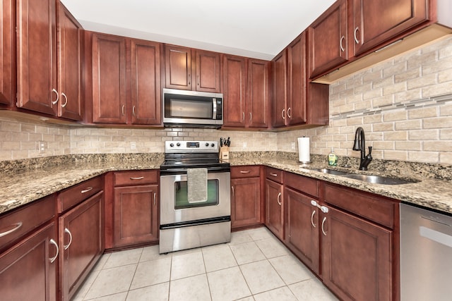 241 W Oakbrook Dr, Ann Arbor, MI 48103 - kitchen with stainless steel appliances, light tile patterned floors, light stone counters, and decorative backsplash