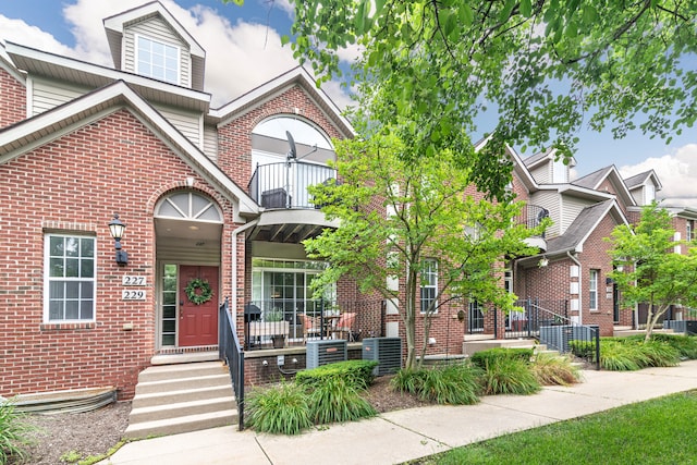 225 W Oakbrook Dr, Ann Arbor, MI 48103 - view of front facade with a balcony, brick siding, and a porch