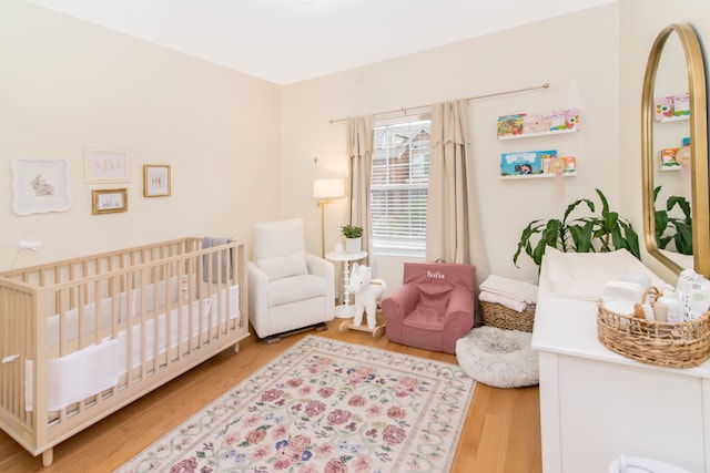 225 W Oakbrook Dr, Ann Arbor, MI 48103 - bedroom featuring a nursery area and wood finished floors