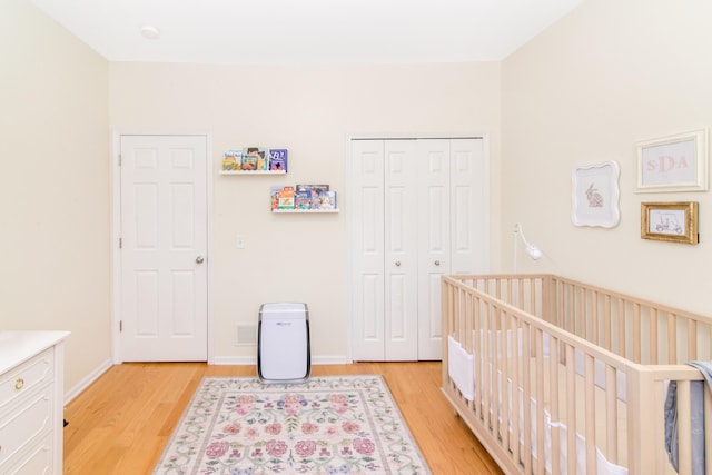 225 W Oakbrook Dr, Ann Arbor, MI 48103 - bedroom with light wood-style flooring, a closet, and a crib