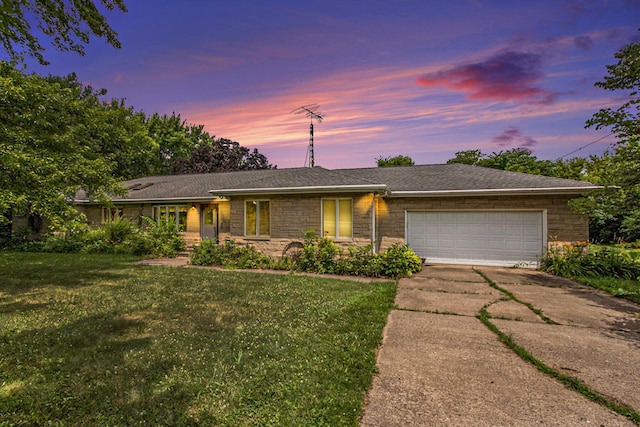 2597 E Glendora Rd, Buchanan, MI 49107 - ranch-style home with concrete driveway, an attached garage, a front lawn, stone siding, and roof with shingles
