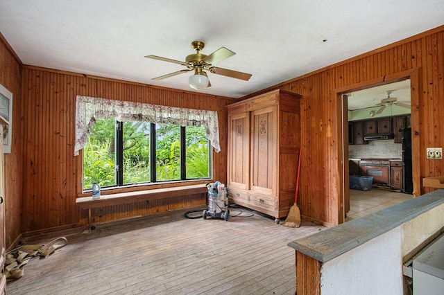 2597 E Glendora Rd, Buchanan, MI 49107 - living room with wooden walls, ceiling fan, and light wood-type flooring