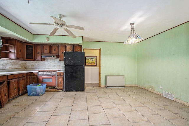 2597 E Glendora Rd, Buchanan, MI 49107 - kitchen with freestanding refrigerator, stove, backsplash, ceiling fan, and light countertops