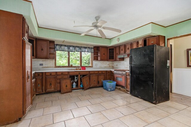 2597 E Glendora Rd, Buchanan, MI 49107 - kitchen featuring freestanding refrigerator, open shelves, under cabinet range hood, ceiling fan, and wainscoting