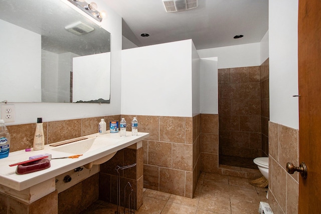 2597 E Glendora Rd, Buchanan, MI 49107 - full bath featuring tile walls, tiled shower, a wainscoted wall, and tile patterned flooring