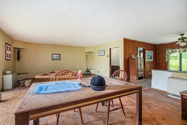 2597 E Glendora Rd, Buchanan, MI 49107 - dining room with ceiling fan, wooden walls, and light wood-style flooring