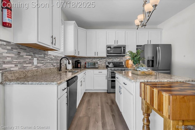 21150 Bryce Ct, Romulus, MI 48174 - kitchen with appliances with stainless steel finishes, wood finished floors, white cabinetry, and decorative backsplash