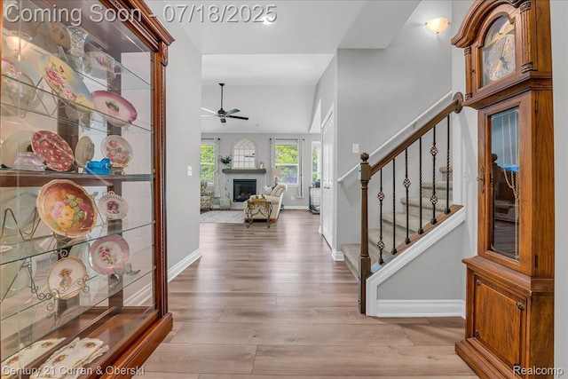 21150 Bryce Ct, Romulus, MI 48174 - foyer entrance featuring a ceiling fan, wood finished floors, stairway, and a glass covered fireplace