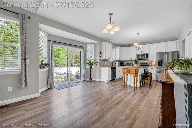 21150 Bryce Ct, Romulus, MI 48174 - kitchen with a chandelier, appliances with stainless steel finishes, light wood-type flooring, and backsplash
